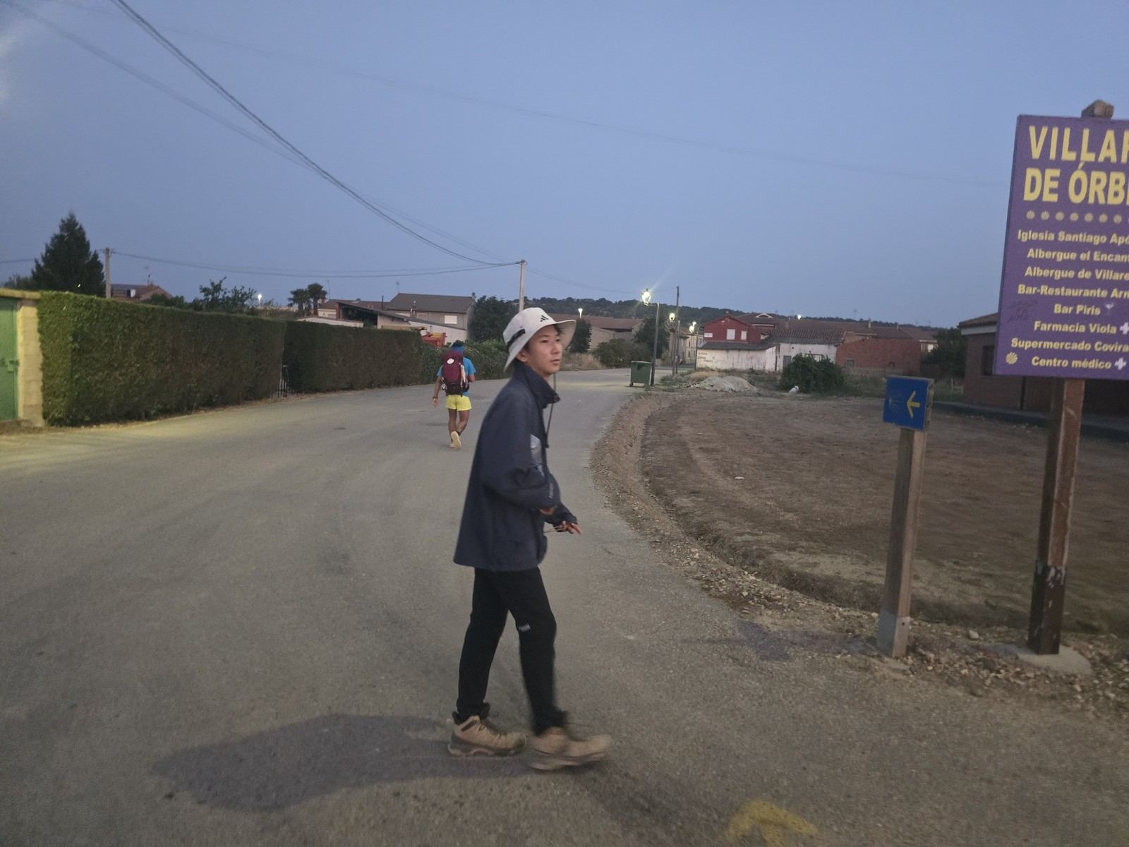 도로변 VILLARES DE ÓRBIGO 표지판. 뒤로 낮은 집들이 보인다