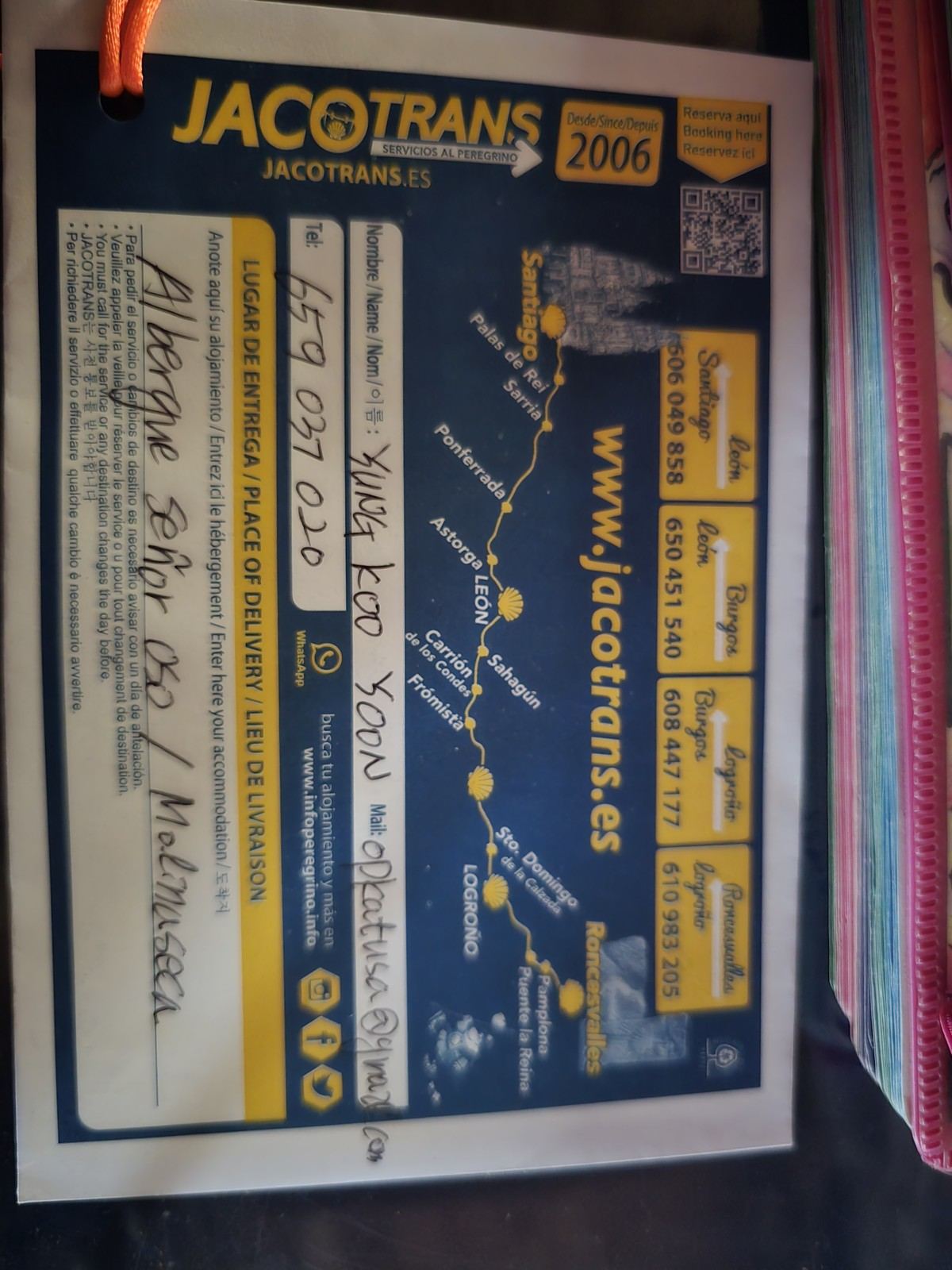 벽에 붙은 배낭 이동 서비스 스티커. JACOTRANS 로고와 지도가 그려져 있다