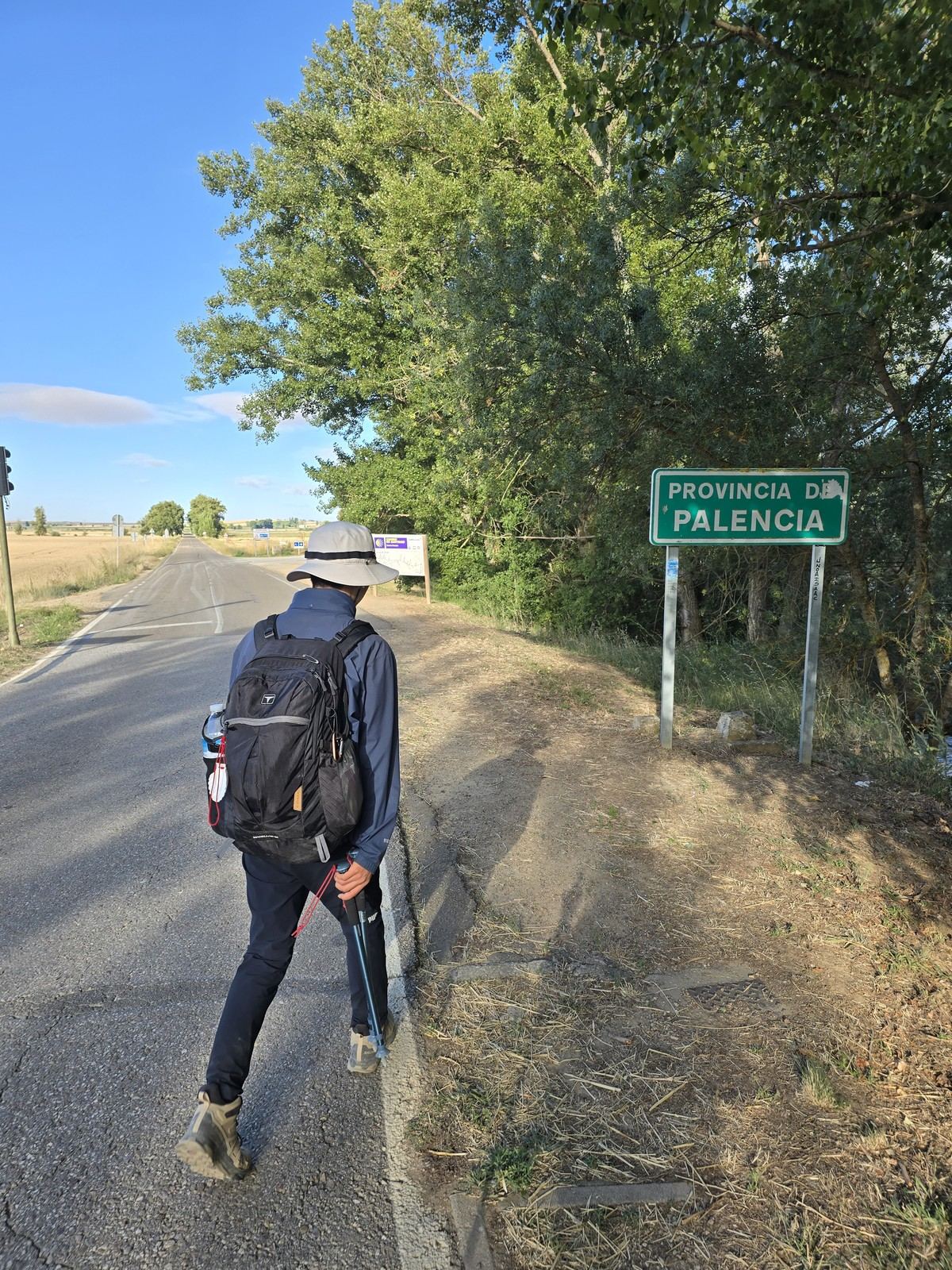 도로변에 선 초록색 표지판에 PROVINCIA DE PALENCIA 라고 적혀 있다. 옆으로 마른 풀과 도로가 이어진다